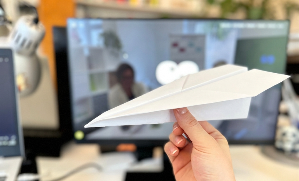 Papierflieger vor Computerbildschirm als Symbol für den Newsletter Versand.